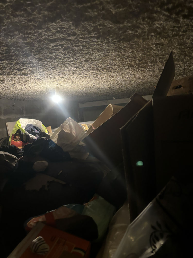 Garage surencombré où les déchets et objets atteignent presque le plafond avant évacuation complète de 25 m³ à Saintes.