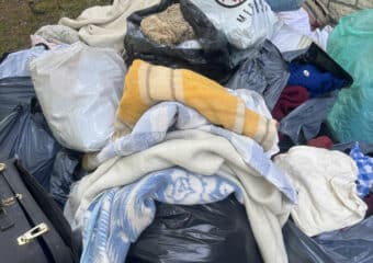 Tas de sacs, textiles et encombrants devant un garage avant leur enlèvement par Clean Sud Ouest à Saint-Georges-de-Didonne.