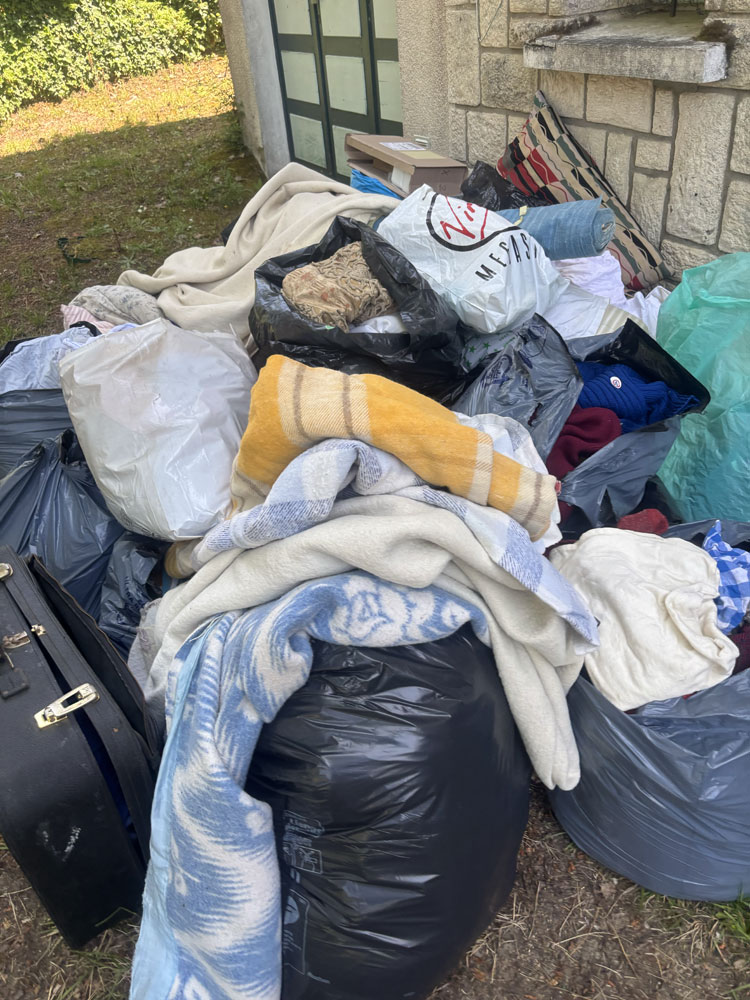 Tas de sacs, textiles et encombrants devant un garage avant leur enlèvement par Clean Sud Ouest à Saint-Georges-de-Didonne.
