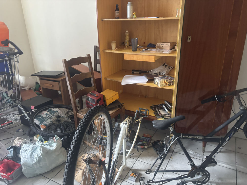Appartement encombré après un squat, rempli d’objets, vélos et déchets avant évacuation complète à Saint-Jean-d’Angély.